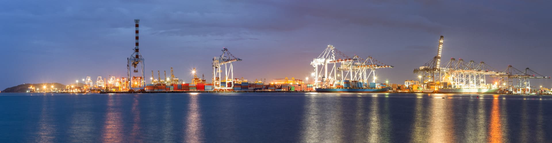Container terminal at night with vessels connected to shore power